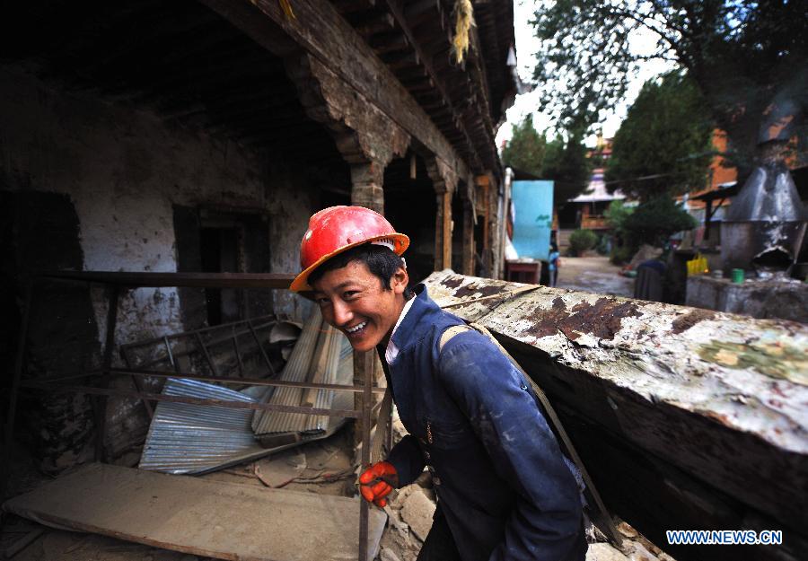 A worker carries a beam as he repairs sutra printing house Meru Monastery in Lhasa, capital of southwest China's Tibet Autonomous Region, Aug. 28, 2015. Local government has dispatched about 30 million yuan (4.698 million US dollars) to overhaul Meru Monastery, which has a history of more than 400 years and suffered from deformation in its beam, pillars and walls. The repair, which started on Aug. 1, is expected to last for one year. (Xinhua/Jigme Dorje)