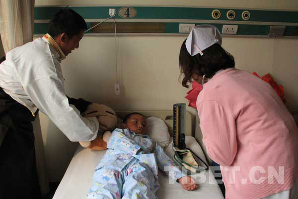 Photo shows that a nurse takes the blood pressure of a Tibetan boy with congenital heart disease at Beijing Tongren Hospital on March 16, 2012.[Photo/ China Tibet Online]