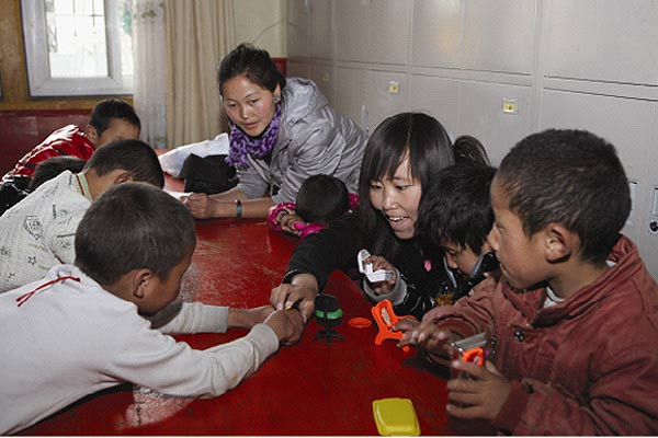 Kyila (in black) plays with students in Kiki's Kindergarten. [Photo/Xinhua]