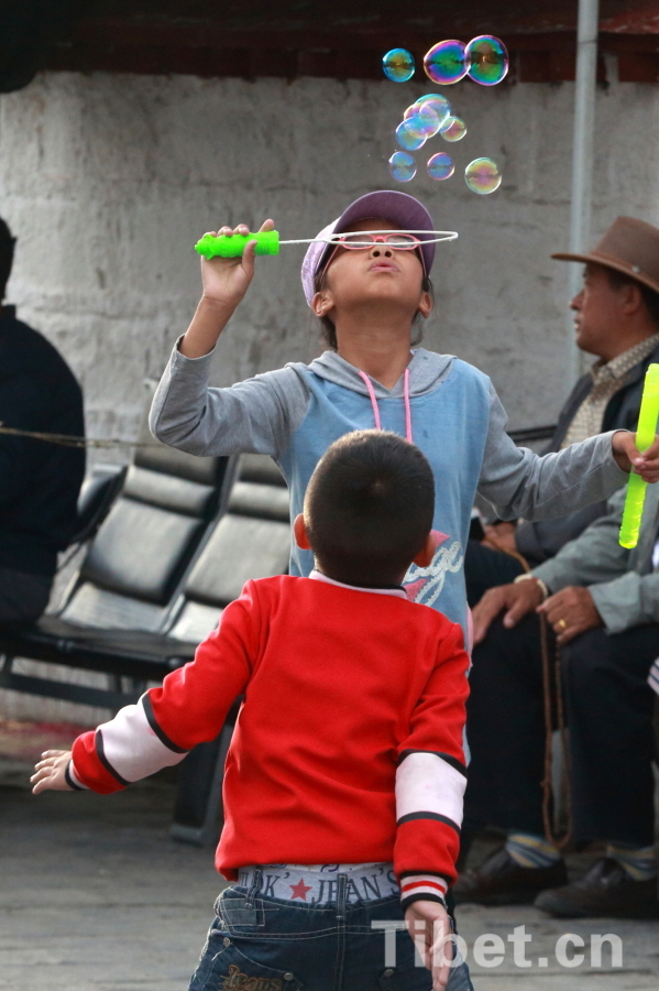 Photo shows two children blowing bubbles in Lhasa. [Photo/ China Tibet Online]