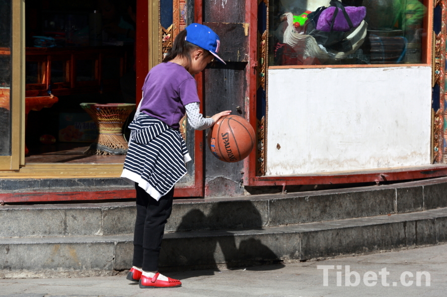 Photo shows a child playing basketball. [Photo/ China Tibet Online]