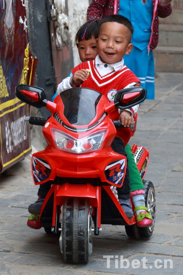 Photo shows two children playing in Lhasa. [Photo/ China Tibet Online]