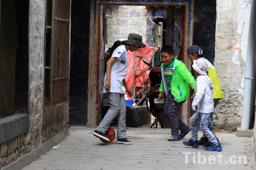 Photo taken on Jun.21, 2015 shows several Tibetan children playing a football game in an alley of the Barkor Street, Lhasa, capital of southwest China’s Tibet Autonomous Region. [Photo/China Tibet Online]