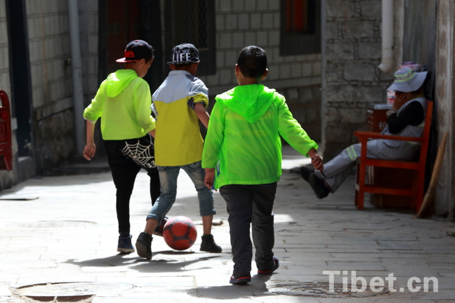 Photo taken on Jun.21, 2015 shows several Tibetan children playing a football game in an alley of the Barkor Street, Lhasa, capital of southwest China’s Tibet Autonomous Region. [Photo/China Tibet Online]