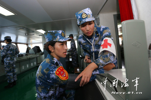 Kunsang Drolma measures Yangji Tsering's blood pressure while in the control room.