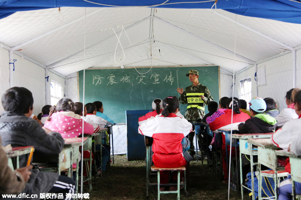 A soldier teaches students how to protect themselves in earthquakes and imparts knowledge of how to reduce the damage of earthquakes to pupils at a makeshift school, in Gyirong county, Shigatse City of Southwest China's Tibet Autonomous Region on Wednesday. A 7.5 magnitude earthquake jolted Gyirong on Tuesday.[Photo/IC]