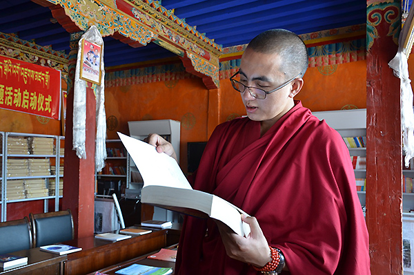 Tenzin Yontan, a Tibetan Buddhist monk, reads a book at the Champa Ling Monastery in Qamdo, a city in the east of the Tibet autonomous region, Aug 7, 2015. [Photo/chinadaily.com.cn]