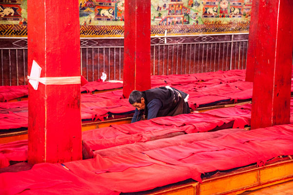 Tibetan Buddhist prays as he crawls from the monestery's entrance to the Buddha statue (not seen in this picture) and kowto, at Champa Ling Monastery. [Photo/chinadaily.com.cn]