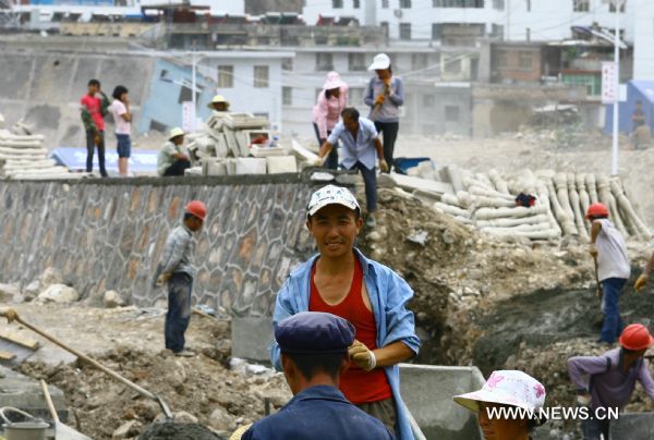 A worker is seen grinning at a building site in Zhouqu County of Gannan Tibetan Autonomous Prefecture, northwest China's Gansu Province, Aug. 2, 2011. After a year's recovery from the deadly mudslide which occurred on Aug. 8, 2010, the beautiful county of Zhouqu has resumed hustle and bustle as the life goes on the way it did. [Photo/Xinhua]