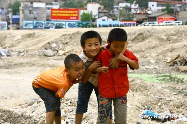 Boys are seen grinning in Zhouqu County of Gannan Tibetan Autonomous Prefecture, northwest China's Gansu Province, Aug. 2, 2011. After a year's recovery from the deadly mudslide which occurred on Aug. 8, 2010, the beautiful county of Zhouqu has resumed hustle and bustle as the life goes on the way it did. [Photo/Xinhua]