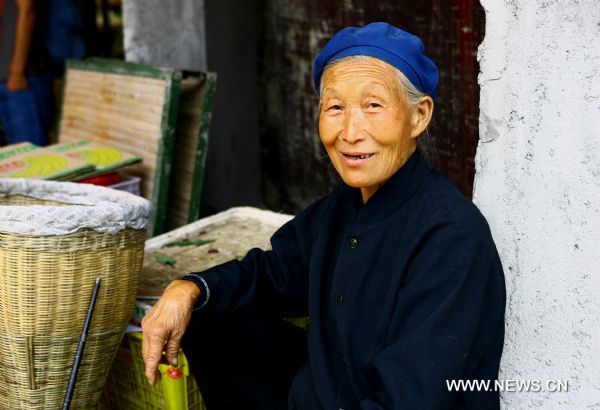 An old resident simles as she looks at the camera in Zhouqu County of Gannan Tibetan Autonomous Prefecture, northwest China's Gansu Province, Aug. 2, 2011. After a year's recovery from the deadly mudslide which occurred on Aug. 8, 2010, the beautiful county of Zhouqu has resumed hustle and bustle as the life goes on the way it did. [Photo/Xinhua]