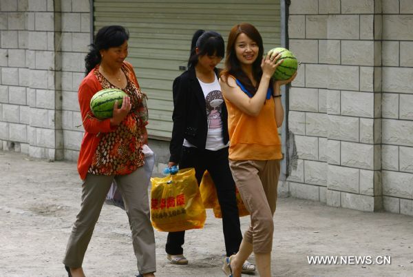 Women carry watermelons in Zhouqu County of Gannan Tibetan Autonomous Prefecture, northwest China's Gansu Province, Aug. 2, 2011. After a year's recovery from the deadly mudslide which occurred on Aug. 8, 2010, the beautiful county of Zhouqu has resumed hustle and bustle as the life goes on the way it did. [Photo/Xinhua]