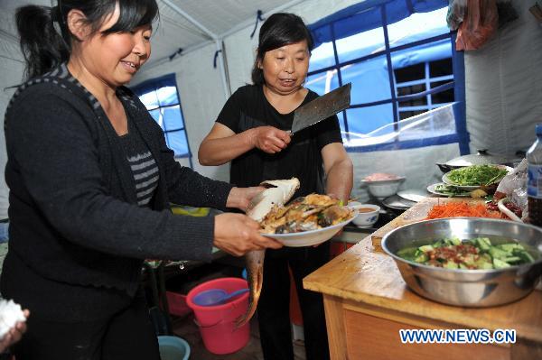 Luo Bingzhen (R) prepares the family-reunion dinner at the temporary shelter in mudslides-hit Zhouqu County, northwest China's Gansu Province, Sept. 22, 2010. Local residents celebrated the first Mid-Autumn Festival after the mudslides at the temporary shelter on Wednesday.