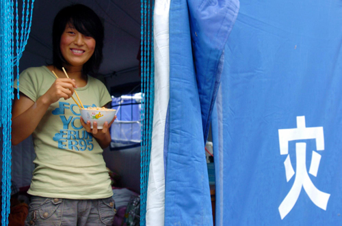Shi Juanfang has a meal in her temporary tent home in the new Shachuan district of Zhouqu county, Northwest China's Gansu province, on Sept 8, 2010.