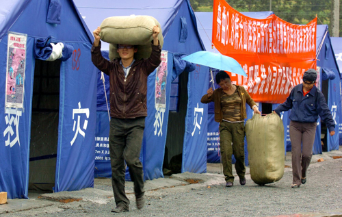 Workers carry clothes to be distributed to mudslide victims.