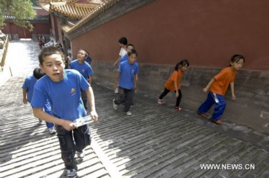 Yao Junfei(front L) walks with other children to climb Wanshou Hill at the Summer Palace in Beijing, capital of China, Aug. 30, 2010.
