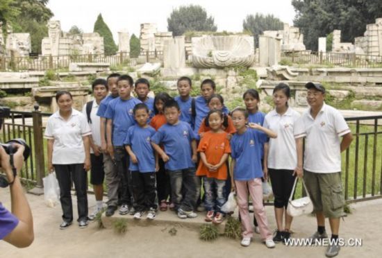 Children from Zhouqu and volunteers pose for group photo at Yuanmingyuan Garden in Beijing, capital of China, Aug. 30, 2010.
