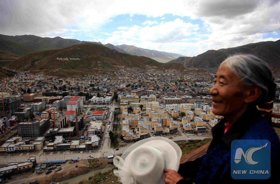 A woman gets a bird's-eye view of Yushu Tibet Autonomous Prefecture, on the Dangdai Mountain, northwest China's Qinghai Province, Aug. 30, 2013. Reconstruction work was underway in Yushu Tibet Autonomous Prefecture, where a strong earthquake occurred on April 14, 2010. (Xinhua/Jia Haiyuan)