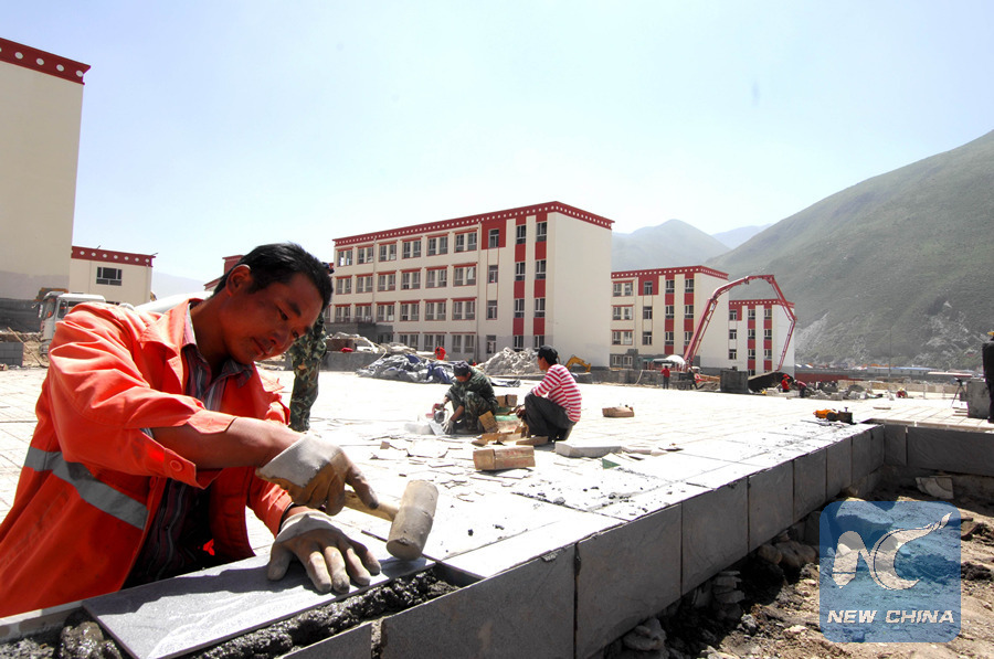 People work at the construction site of an ethnic middle school in Yushu Tibetan Autonomous Prefecture on Aug. 9, 2011. (Xinhua/Wu Guangyu)