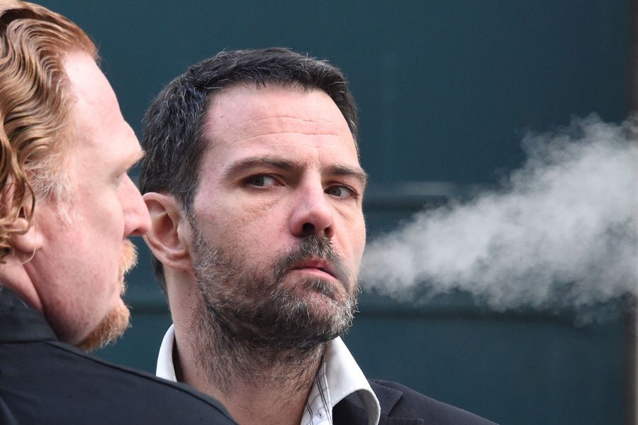 French convicted rogue trader Jerome Kerviel (R), flanked by his lawyer Benoit Pruvost (L), smokes outside the courthouse of Versailles, on January 20, 2016 as he appears on his liability in the loss of 4.9 billion euros incurred by the bank Societe Generale in 2008.[Photo/CFP]